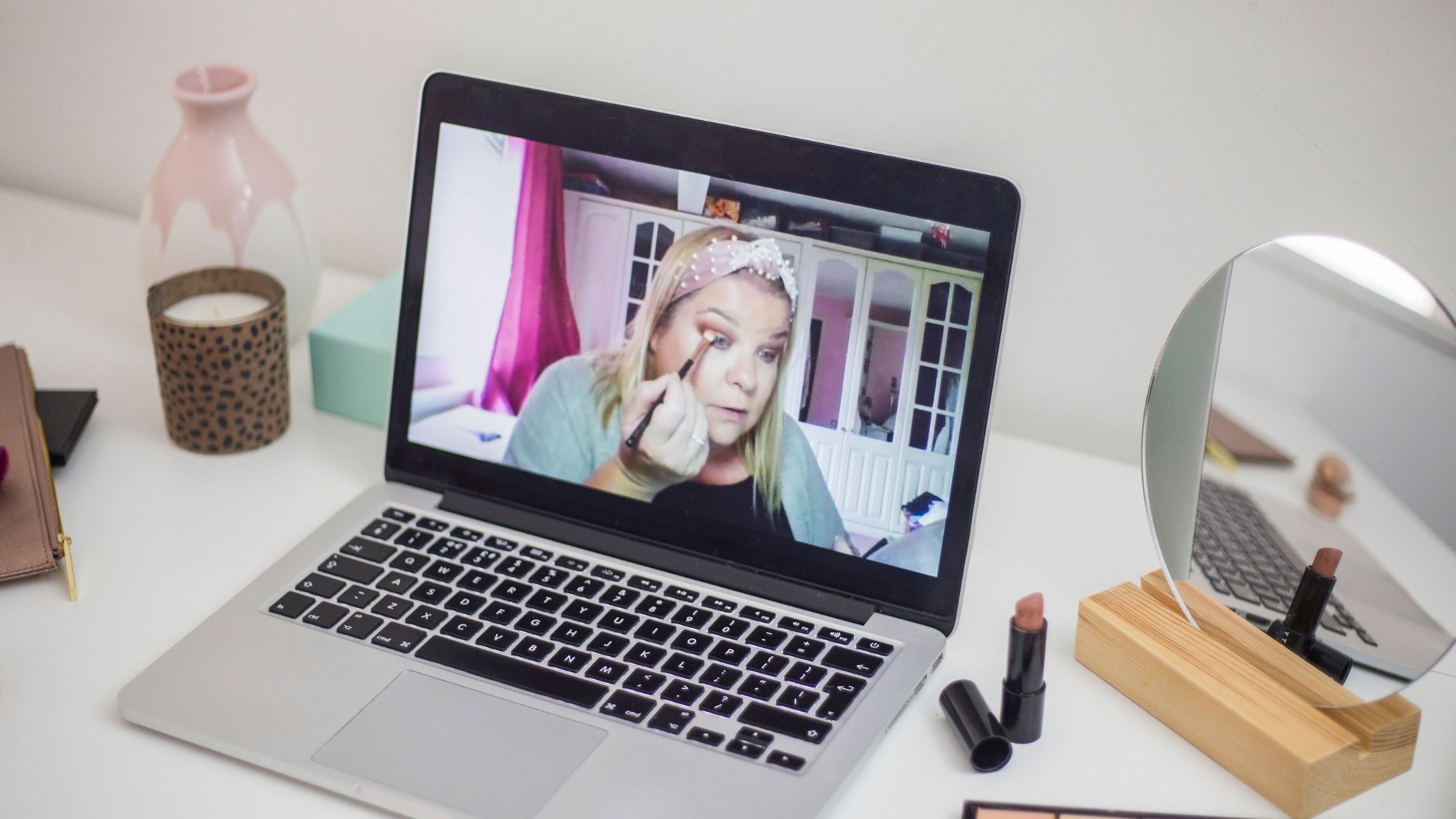 makeup artist applying makeup on herself on a laptop screen during an online makeup lesson